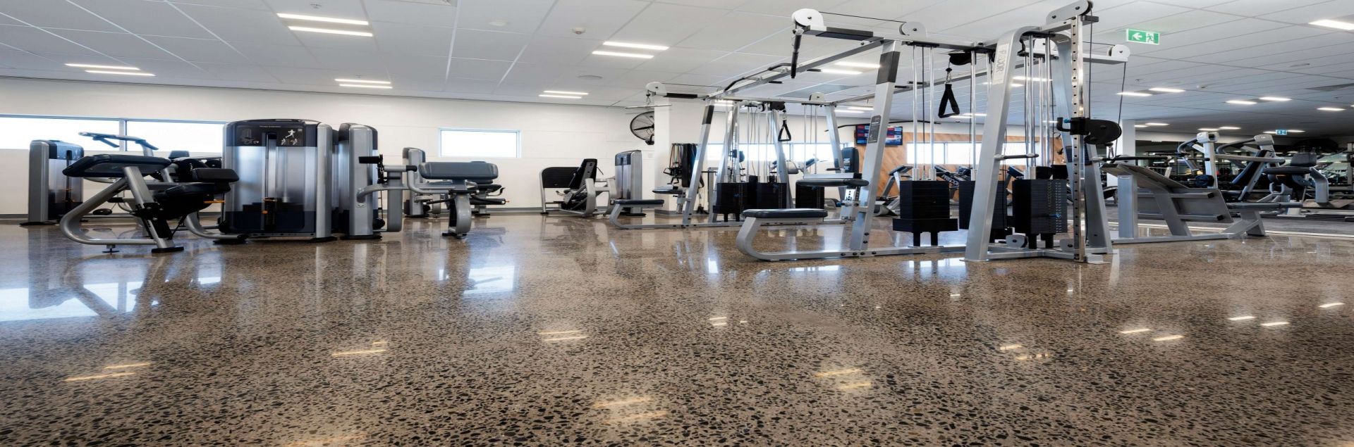 Polished concrete in gym surrounded by weight lifting equipment