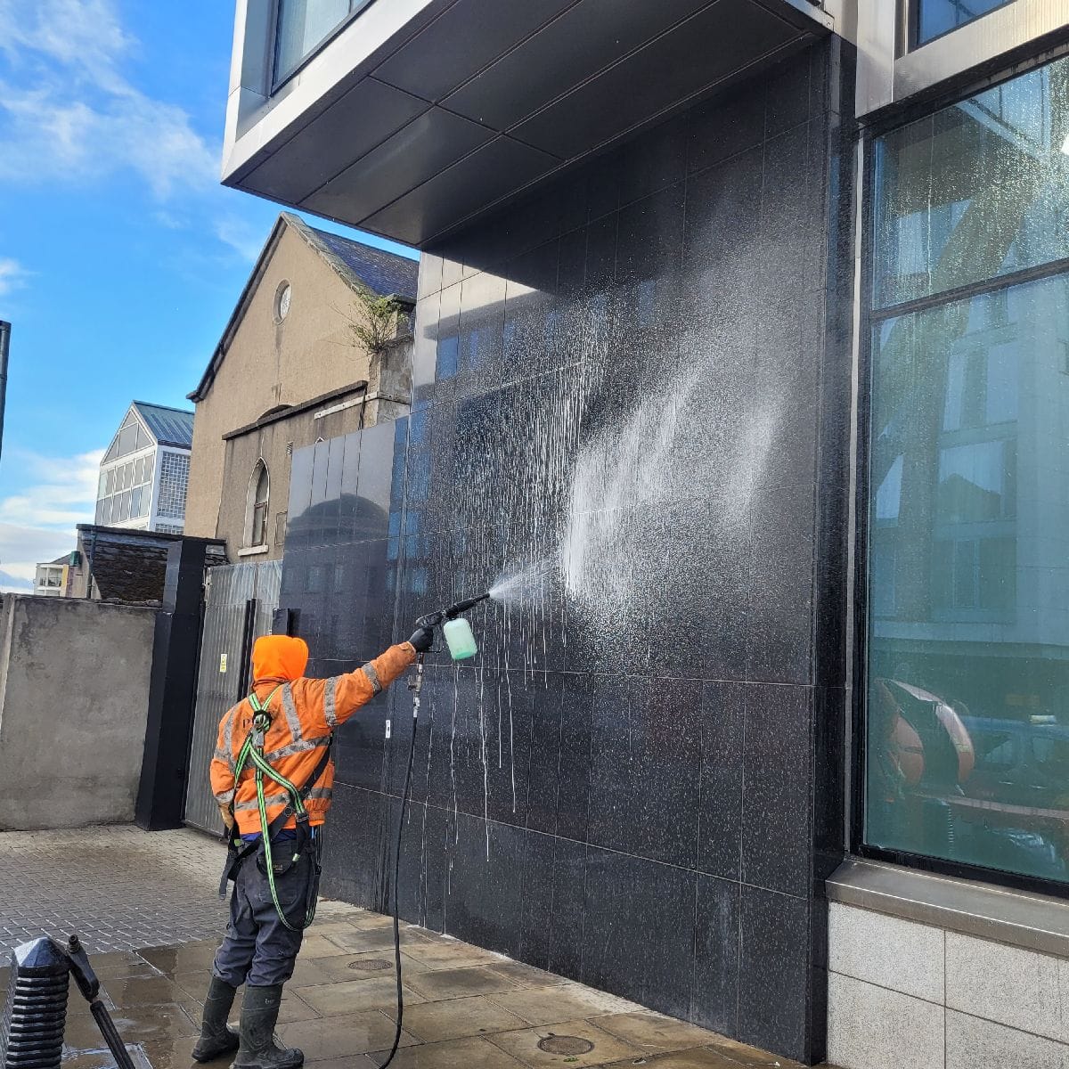PMAC operator spraying facade 